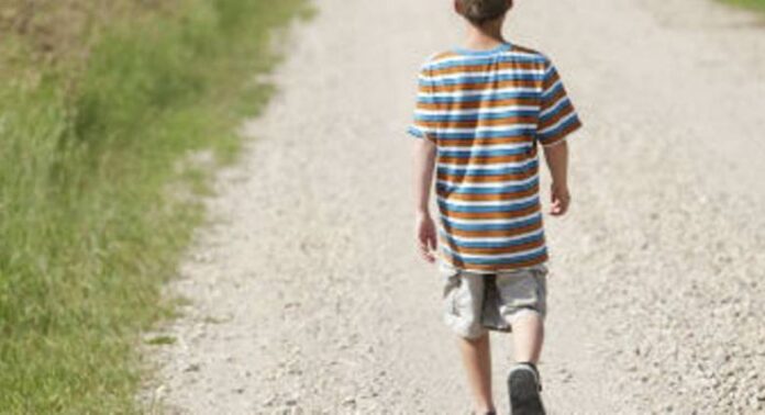 boy-walking-road-field