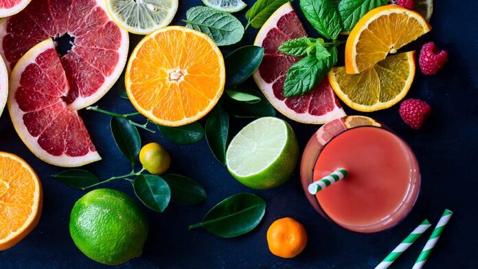 Fresh citrus slices and juice on black background top view
