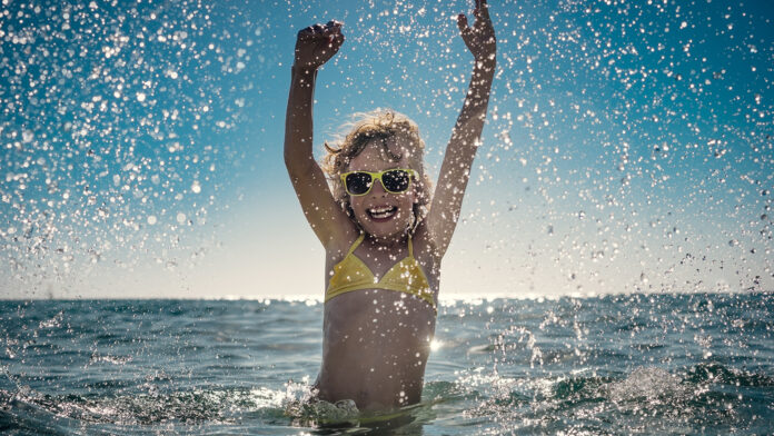 Happy child playing in the sea